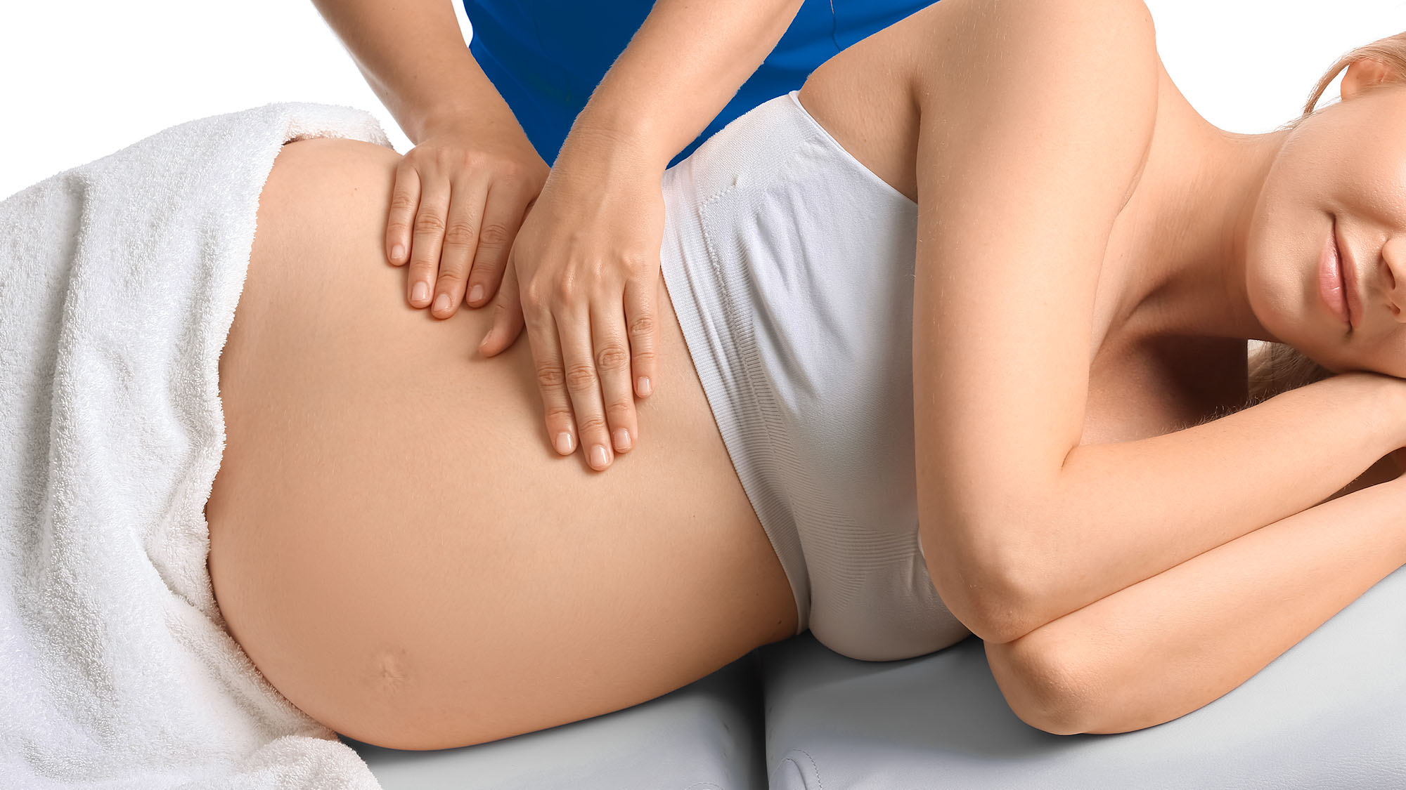 Prenatal Massage. Close up on pregnant women's belly. She is receiving a massage on the side of her belly.