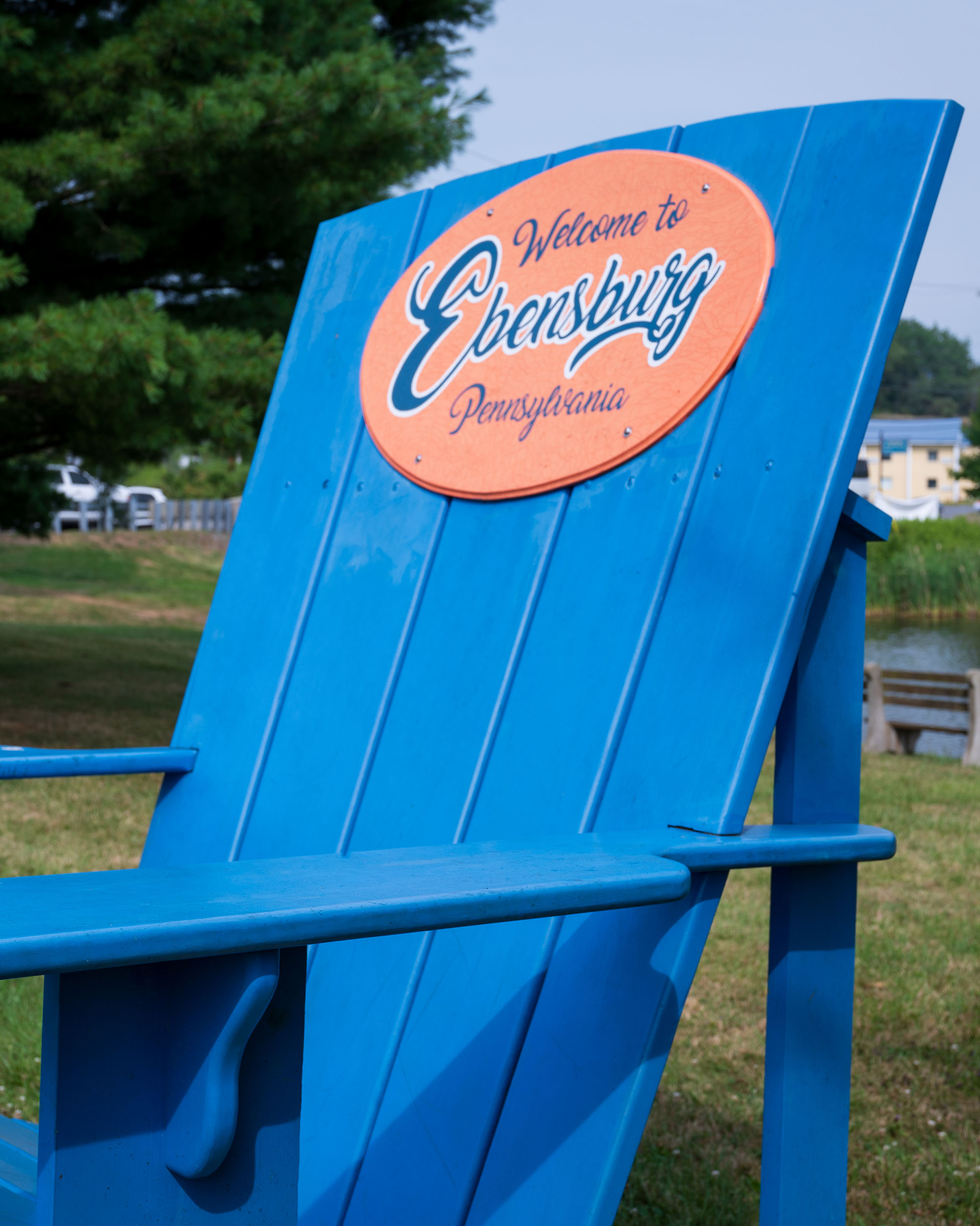 Giant blue Adirondack chair with welcome to Ebensburg sign. It is known as Ebensburg's Major's Chair.